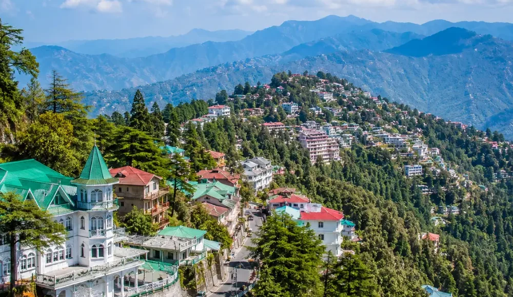 Bright morning view of Mussoorie hill station with green valleys, mountain roads, and clear Himalayan scenery