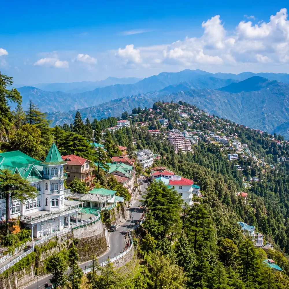 Bright morning view of Mussoorie hill station with green valleys, mountain roads, and clear Himalayan scenery