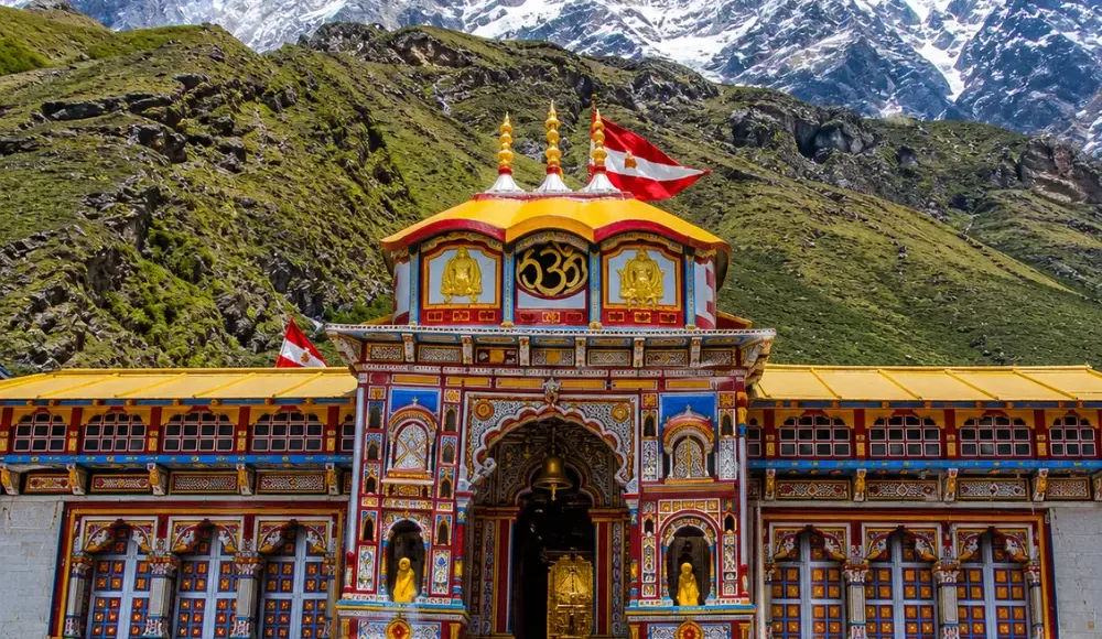 Bright morning view of Badrinath Temple with colorful facade, Himalayan mountains, and clear sacred valley scenery