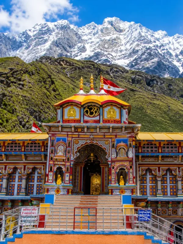 Bright morning view of Badrinath Temple with colorful facade, Himalayan mountains, and clear sacred valley scenery