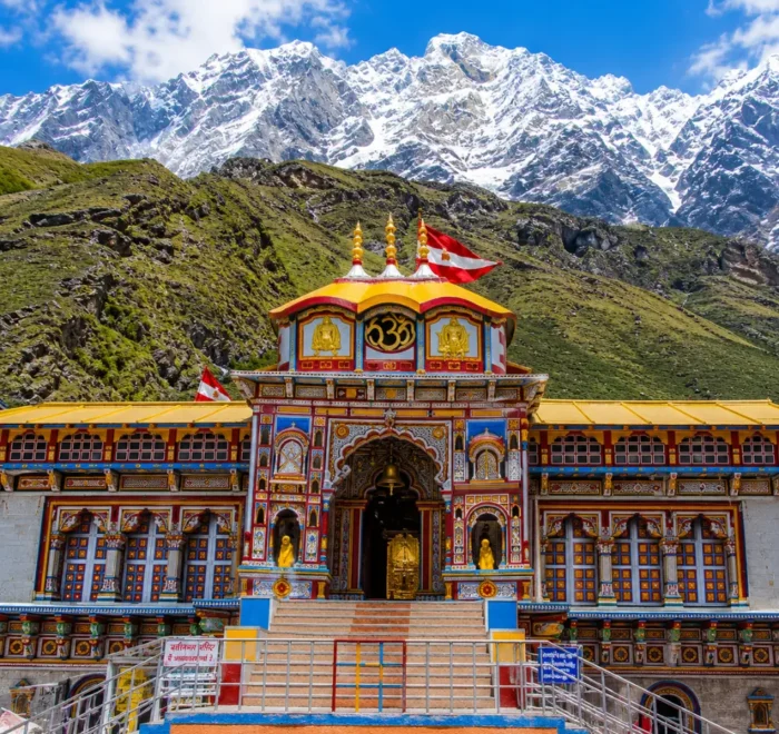 Bright morning view of Badrinath Temple with colorful facade, Himalayan mountains, and clear sacred valley scenery