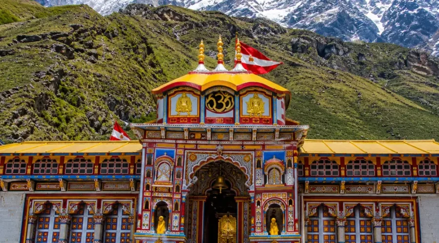 Bright morning view of Badrinath Temple with colorful facade, Himalayan mountains, and clear sacred valley scenery