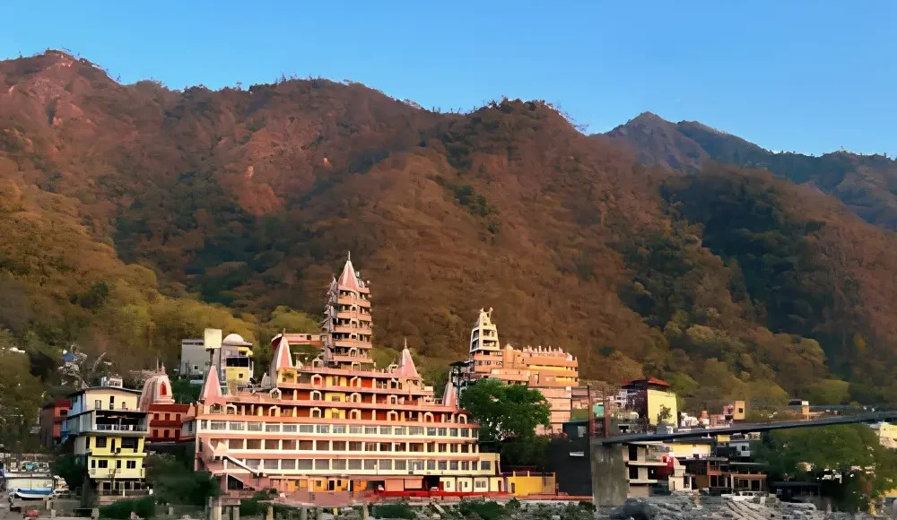 Grand Uttarakhand Explorer tour with riverfront town, mountain backdrop, scenic hills and peaceful Uttarakhand landscape