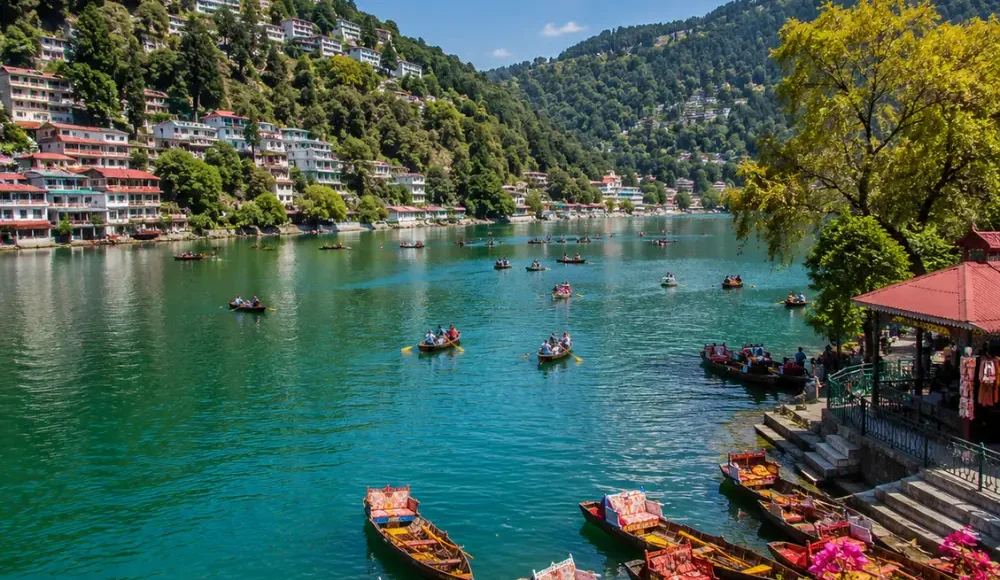 Bright morning view of Naini Lake in Nainital with green hills, clear water, and peaceful mountain scenery