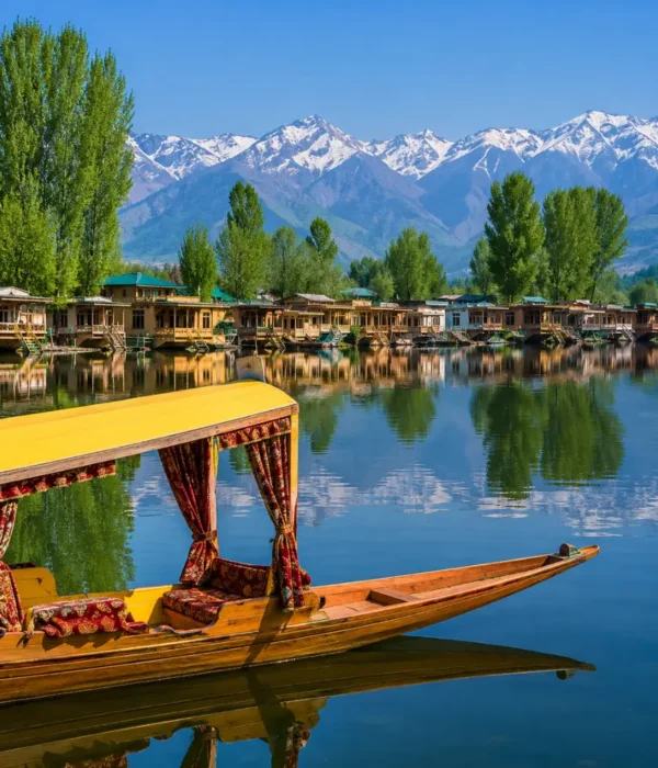Beautiful Srinagar Dal Lake view with colorful shikara, houseboats, calm water reflections, and snow-capped mountains.