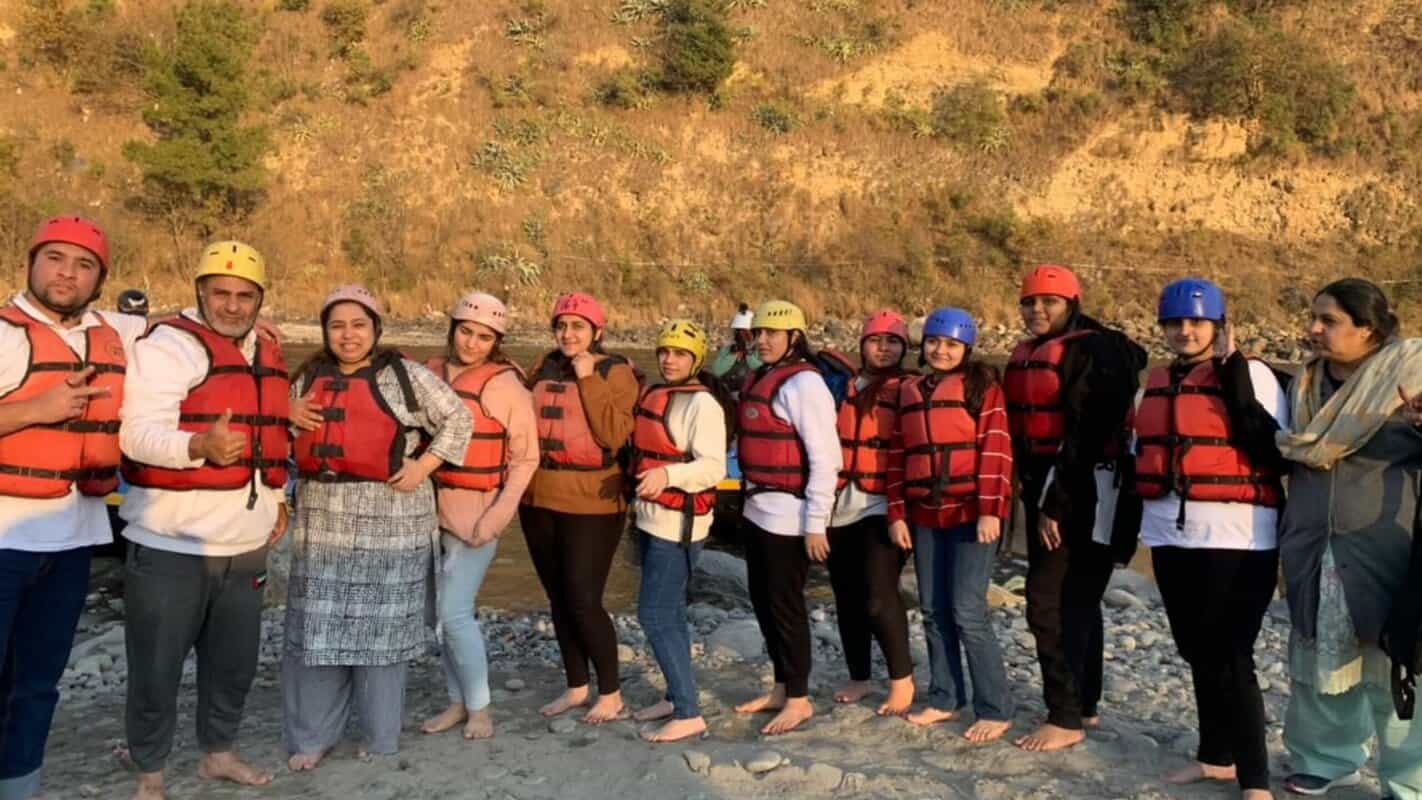 Adventure river rafting team in India with safety gear, scenic natural landscape, and outdoor adventure travel experiences.