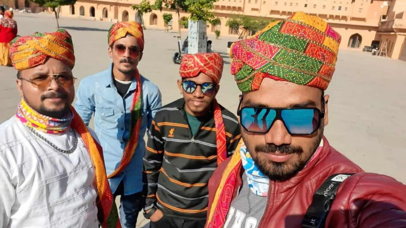 Colorful traditional Rajasthani turbans worn by group of tourists in India, exploring historic forts and palaces.