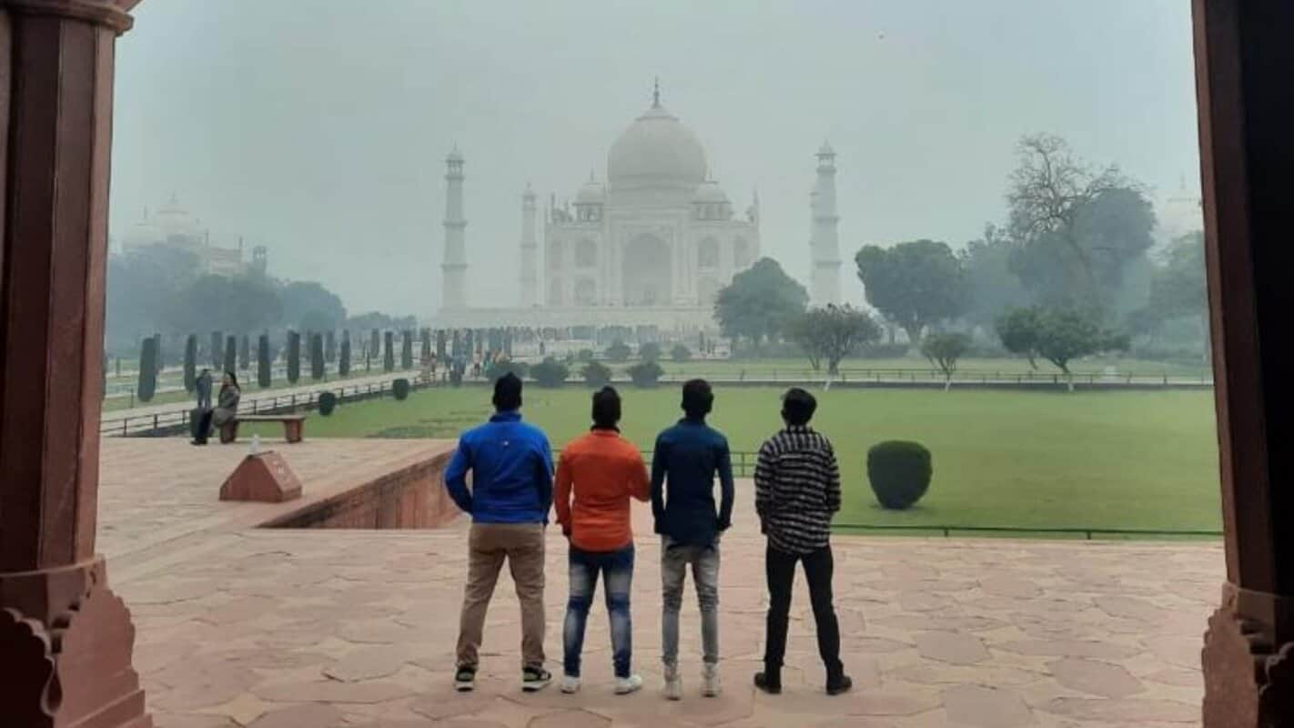 Taj Mahal view with four friends standing and enjoying the iconic monument of India, perfect for travel and cultural exploration in India Tours & Travels.