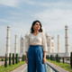 Relaxing view of the Taj Mahal with a woman in traditional attire in Agra, India, showcasing iconic Indian landmarks and cultural heritage.