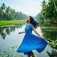 India Tours & Travels scenic river cruise with traditional boat and lush greenery background.