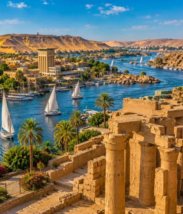 Bright daytime view of Aswan Egypt with Nile River, felucca sailboats, ancient ruins, palm trees, and desert hills.