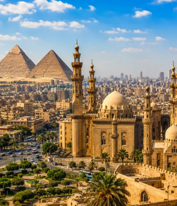 Bright daytime view of Cairo with historic mosque architecture, city skyline, palm trees, and Giza pyramids.