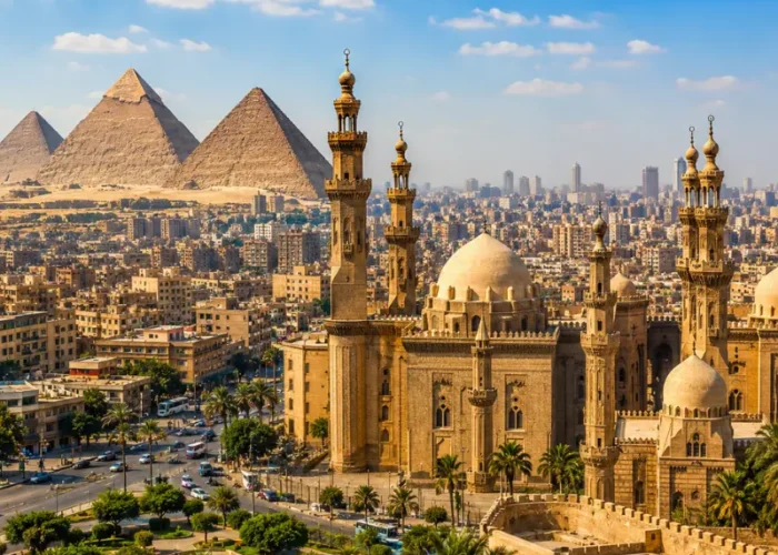 Bright daytime view of Cairo with historic mosque architecture, city skyline, palm trees, and Giza pyramids.