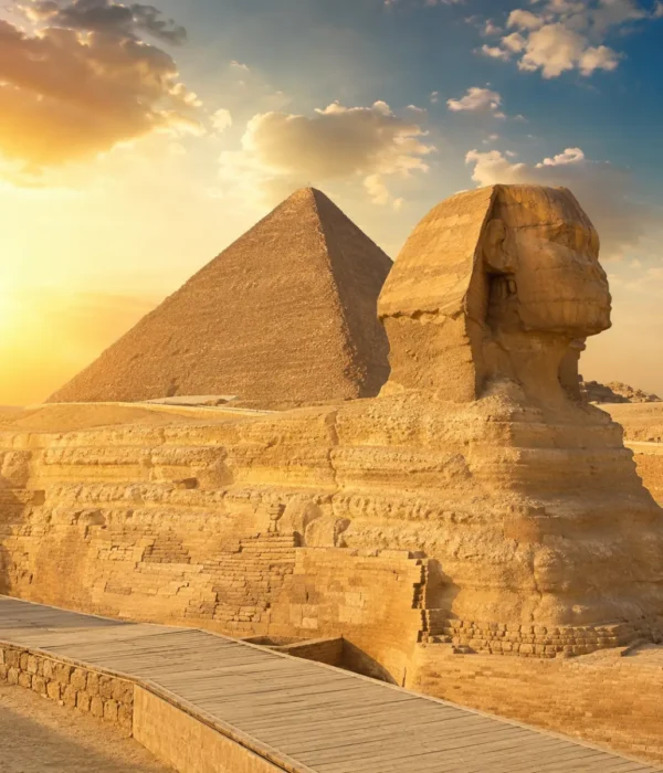 Great Sphinx of Giza with the Pyramid of Khafre in the background under warm golden light in Egypt.
