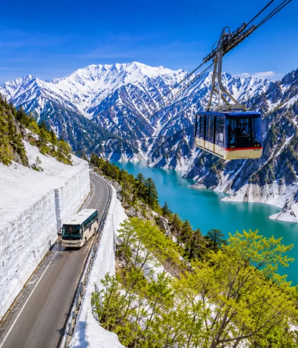 Luxury Japan Alpine Route featuring the iconic Tateyama Kurobe Snow Corridor, crystal-clear turquoise Kurobe Lake, panoramic snow-covered peaks, an alpine cable car, and a scenic mountain road under bright blue skies. No people.