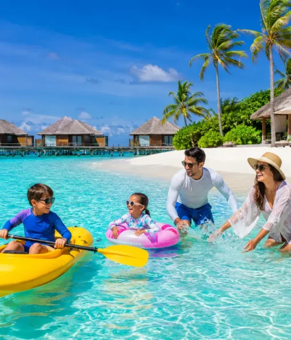 Family enjoying Maldives beach resort with turquoise lagoon, white sand, palm trees, and tropical island scenery.