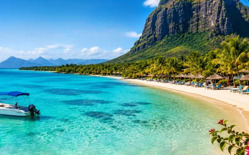 Mauritius beach with turquoise lagoon, palm-lined shoreline, luxury resort and Le Morne mountain in daylight