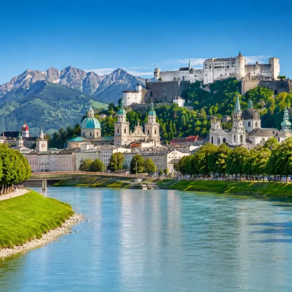 Luxury daytime view of Salzburg, Austria with Hohensalzburg Fortress, Salzach River, churches, and alpine mountains.