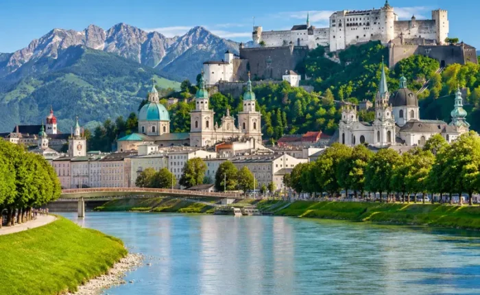 Luxury daytime view of Salzburg, Austria with Hohensalzburg Fortress, Salzach River, churches, and alpine mountains.