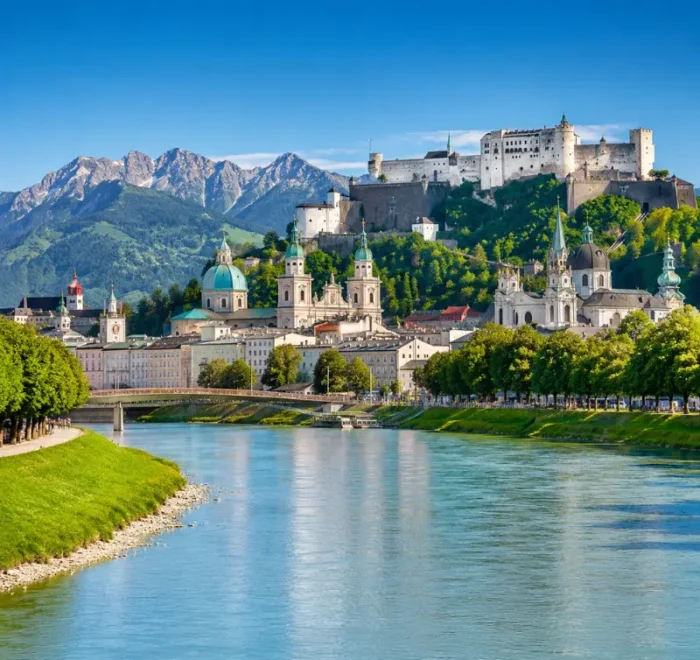 Luxury daytime view of Salzburg, Austria with Hohensalzburg Fortress, Salzach River, churches, and alpine mountains.