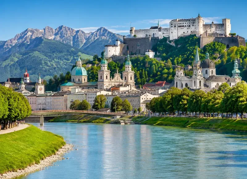 Luxury daytime view of Salzburg, Austria with Hohensalzburg Fortress, Salzach River, churches, and alpine mountains.