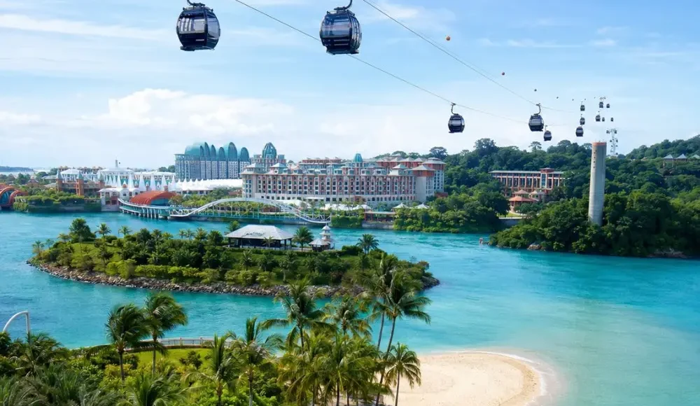 Sentosa Island Singapore with cable cars, turquoise sea, palm beach, and resort skyline in bright morning light.