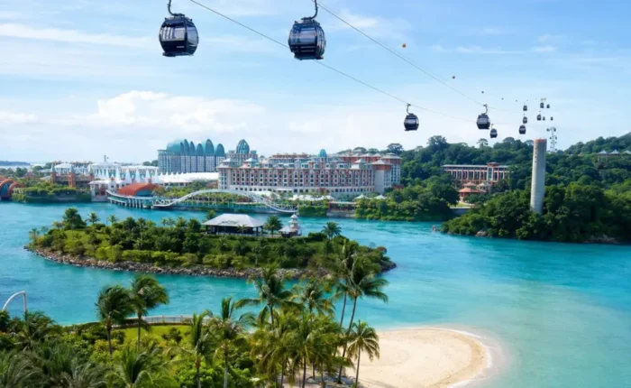 Sentosa Island Singapore with cable cars, turquoise sea, palm beach, and resort skyline in bright morning light.