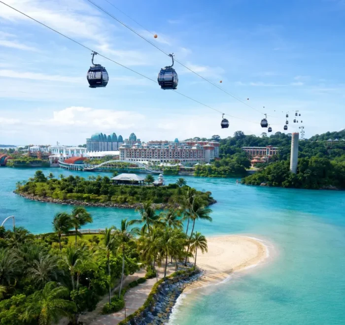 Sentosa Island Singapore with cable cars, turquoise sea, palm beach, and resort skyline in bright morning light.