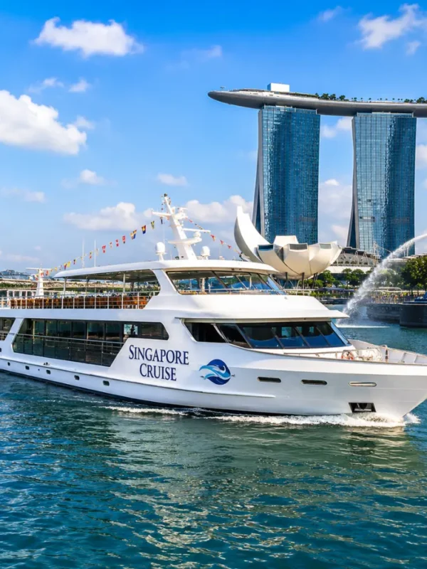 Luxury Singapore cruise ship near Marina Bay with skyline, blue water, and bright morning travel atmosphere.