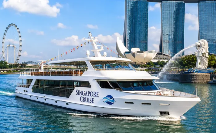 Luxury Singapore cruise ship near Marina Bay with skyline, blue water, and bright morning travel atmosphere.