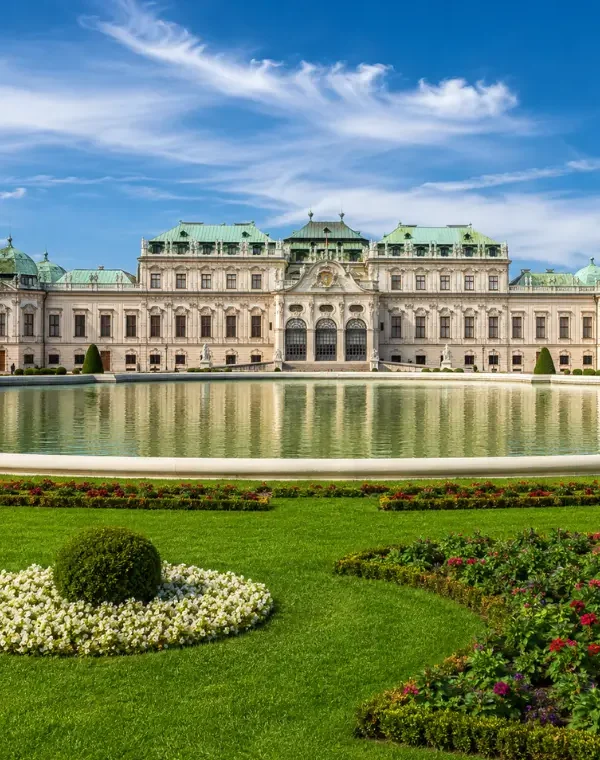 Luxury daytime view of Vienna’s Belvedere Palace with formal gardens, reflecting pool, and elegant Baroque architecture.