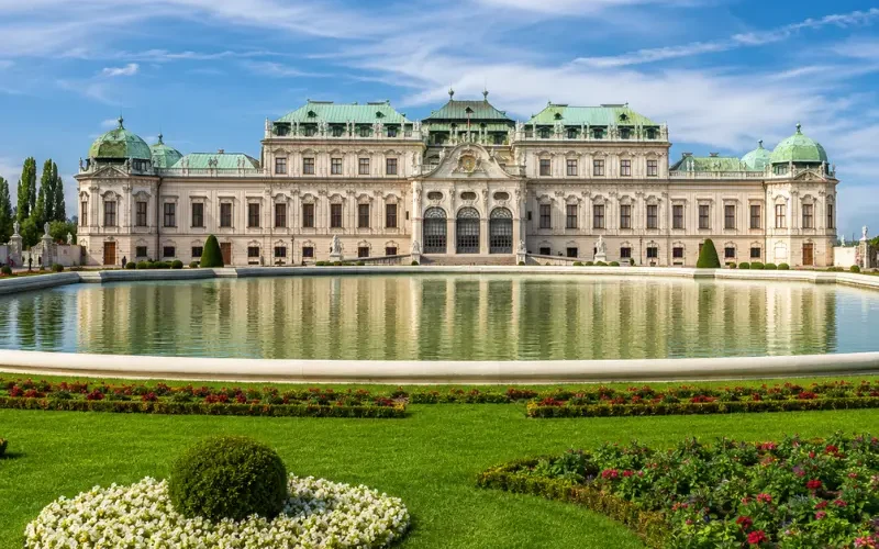 Luxury daytime view of Vienna’s Belvedere Palace with formal gardens, reflecting pool, and elegant Baroque architecture.