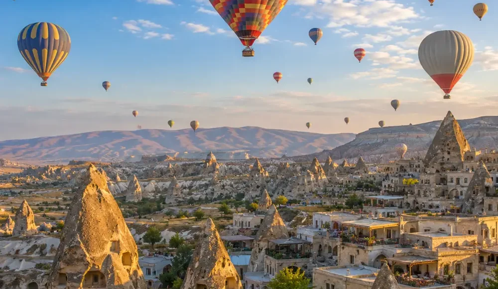Cappadocia Turkey with hot air balloons, fairy chimneys, rocky valleys, and bright clear morning atmosphere.