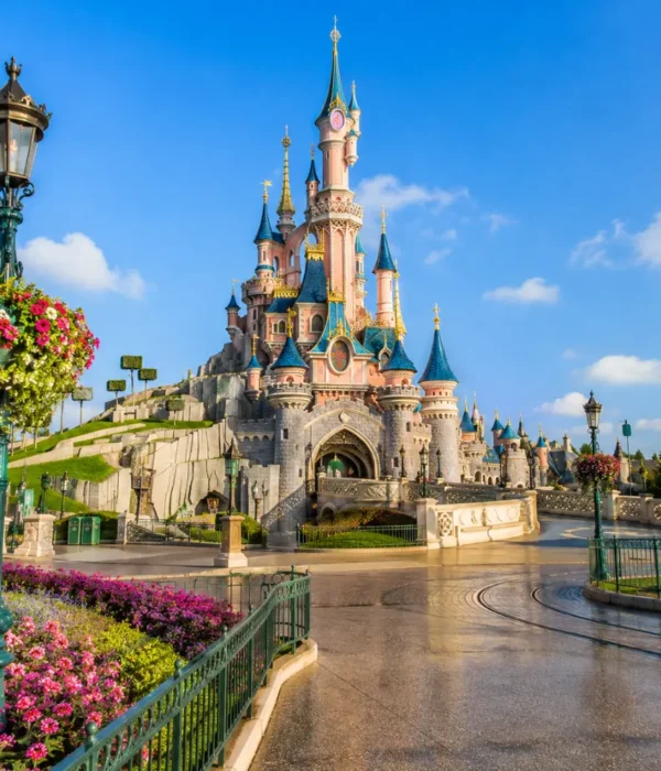 Disneyland Paris castle with fantasy gardens, clean pathways, blue sky, and bright morning family travel atmosphere