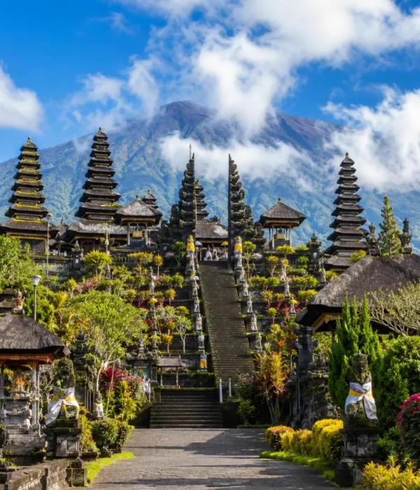 Besakih Temple Bali with Mount Agung views, traditional temple gates, lush greenery, and bright morning atmosphere.