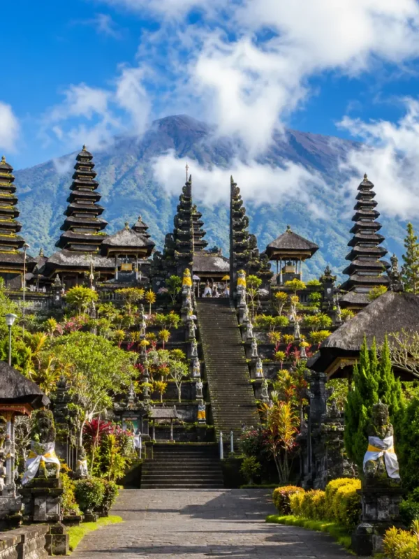 Besakih Temple Bali with Mount Agung views, traditional temple gates, lush greenery, and bright morning atmosphere.