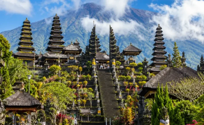 Besakih Temple Bali with Mount Agung views, traditional temple gates, lush greenery, and bright morning atmosphere.