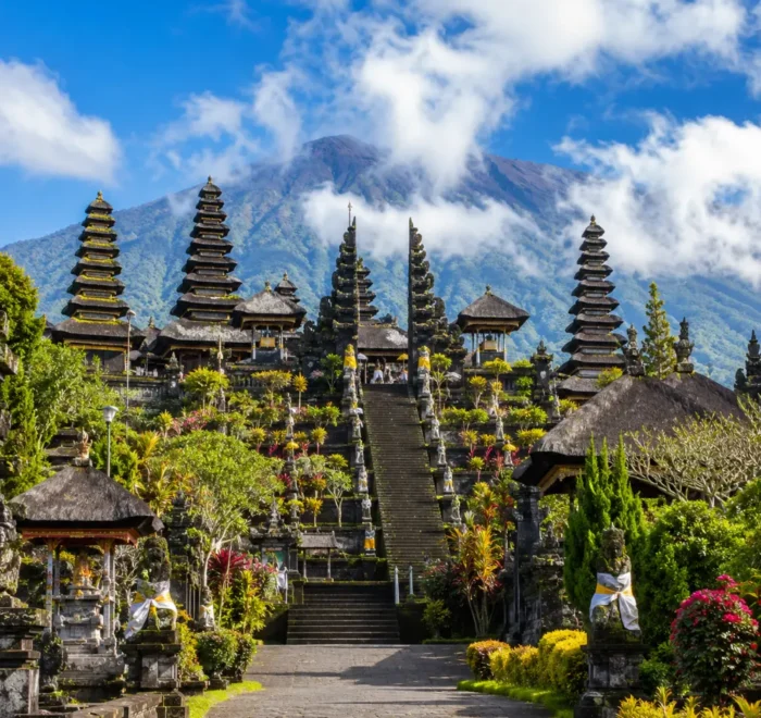 Besakih Temple Bali with Mount Agung views, traditional temple gates, lush greenery, and bright morning atmosphere.