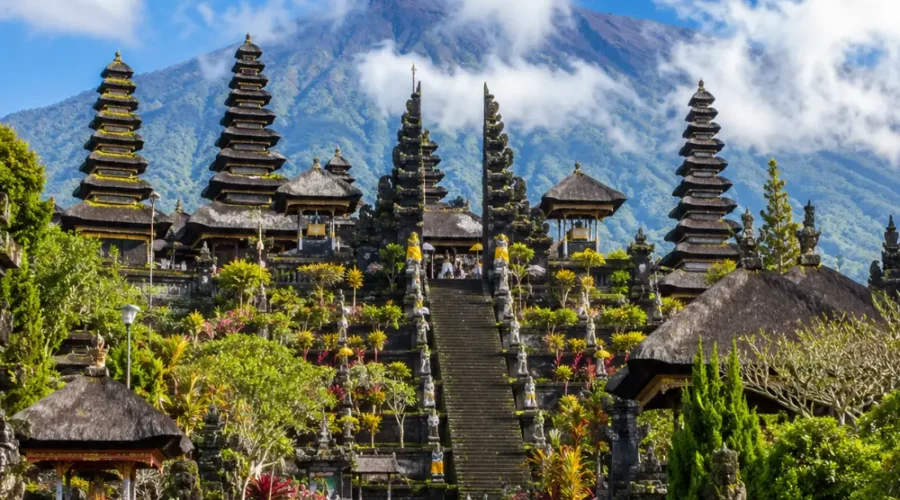 Besakih Temple Bali with Mount Agung views, traditional temple gates, lush greenery, and bright morning atmosphere.
