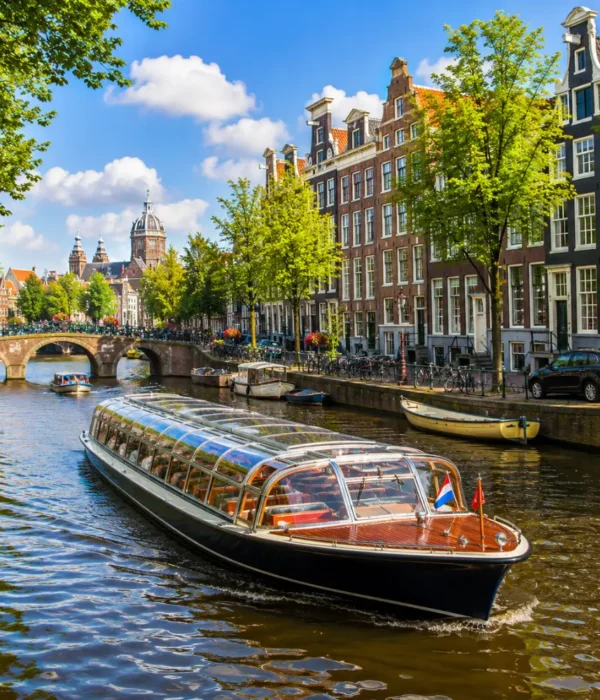 Amsterdam canal cruise with historic houses, arched bridges, calm waterways, and bright morning European atmosphere.