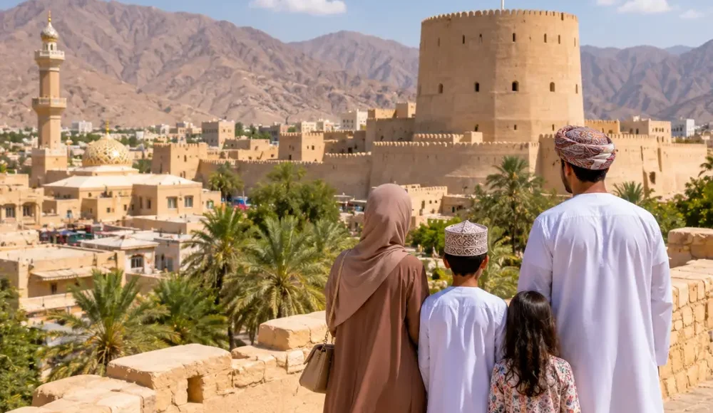 Family exploring Nizwa Fort with the Omani flag and Hajar Mountains in Oman