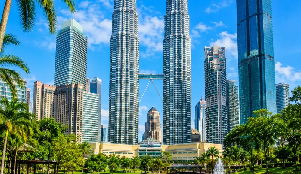 Ultra-clear square view of Kuala Lumpur with the Petronas Twin Towers, tropical greenery, and a premium modern cityscape.
