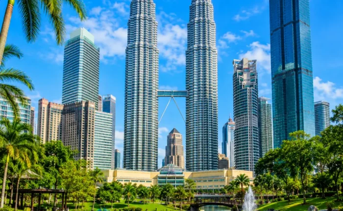 Ultra-clear square view of Kuala Lumpur with the Petronas Twin Towers, tropical greenery, and a premium modern cityscape.