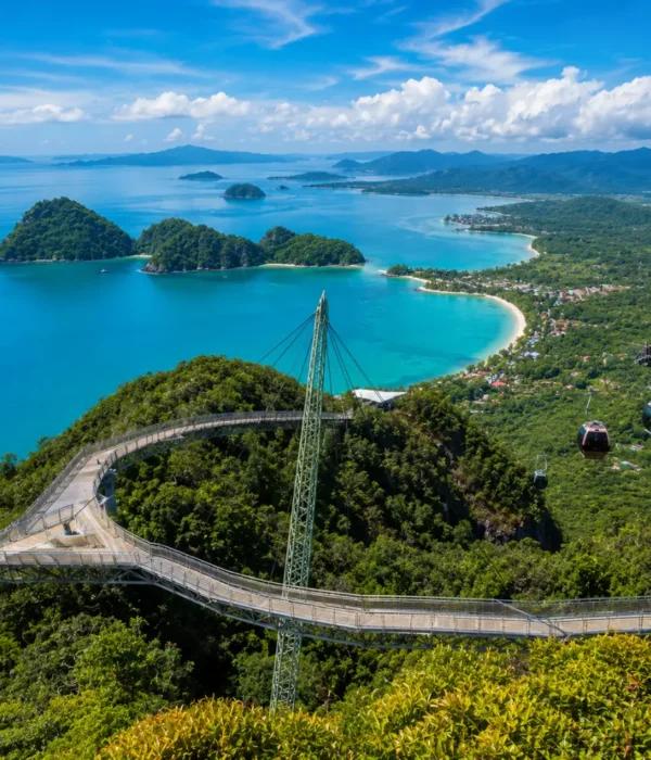 Crystal-clear tropical beach in Langkawi with turquoise water, limestone islands, luxury resort villas, and lush rainforest scenery.