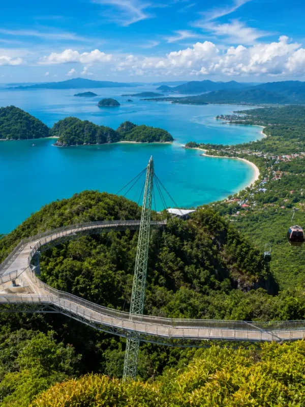 Crystal-clear tropical beach in Langkawi with turquoise water, limestone islands, luxury resort villas, and lush rainforest scenery.