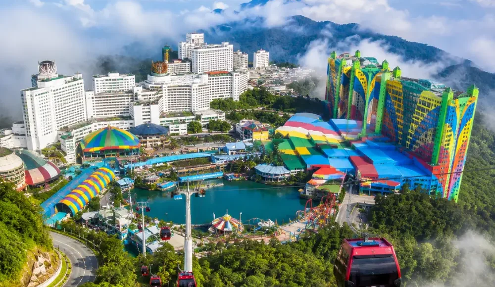 Luxury view of Genting Highlands with modern hilltop resorts, lush rainforest, cable cars, and misty mountain scenery.