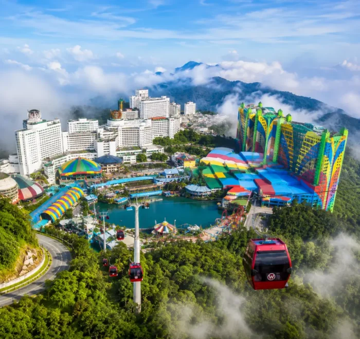 Luxury view of Genting Highlands with modern hilltop resorts, lush rainforest, cable cars, and misty mountain scenery.