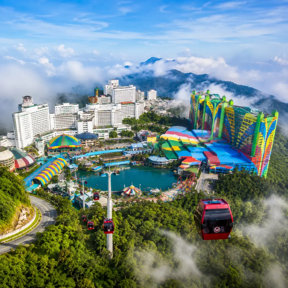 Luxury view of Genting Highlands with modern hilltop resorts, lush rainforest, cable cars, and misty mountain scenery.
