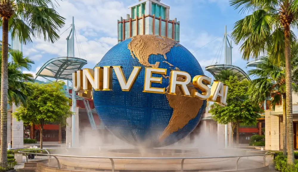 Universal Studios Singapore entrance with iconic globe, tropical palms, and bright morning travel atmosphere.