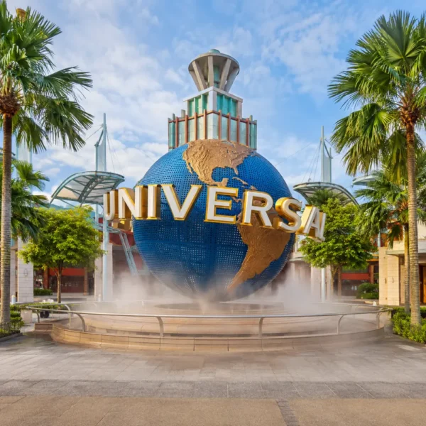 Universal Studios Singapore entrance with iconic globe, tropical palms, and bright morning travel atmosphere.